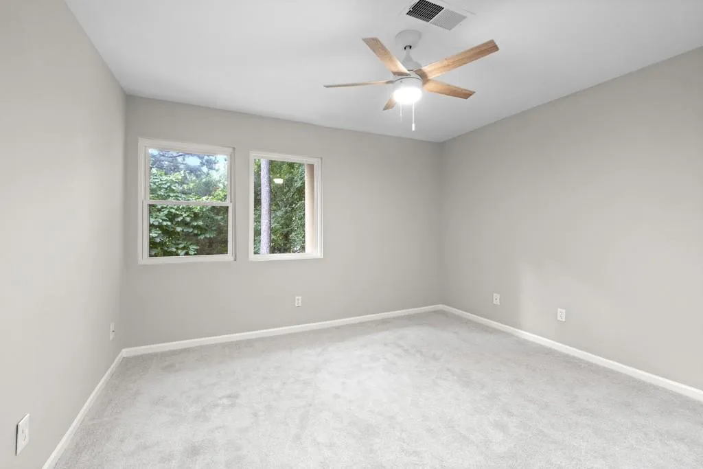 Carpeted empty room with ceiling fan