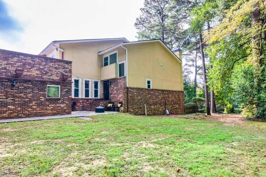 Back of house with a yard and a patio