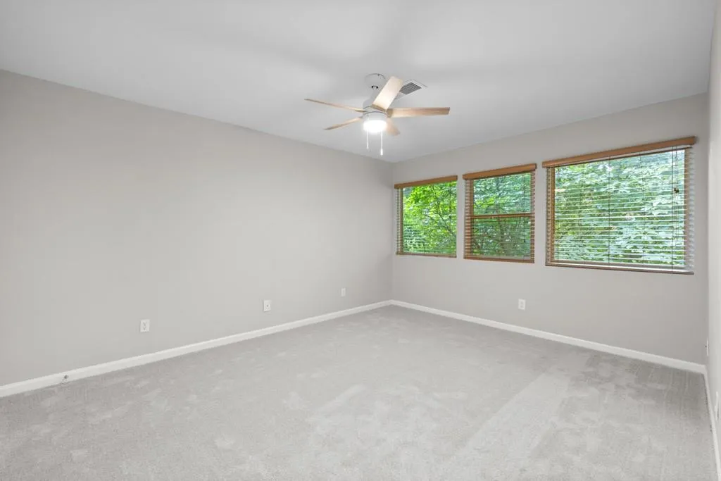 Carpeted empty room with ceiling fan