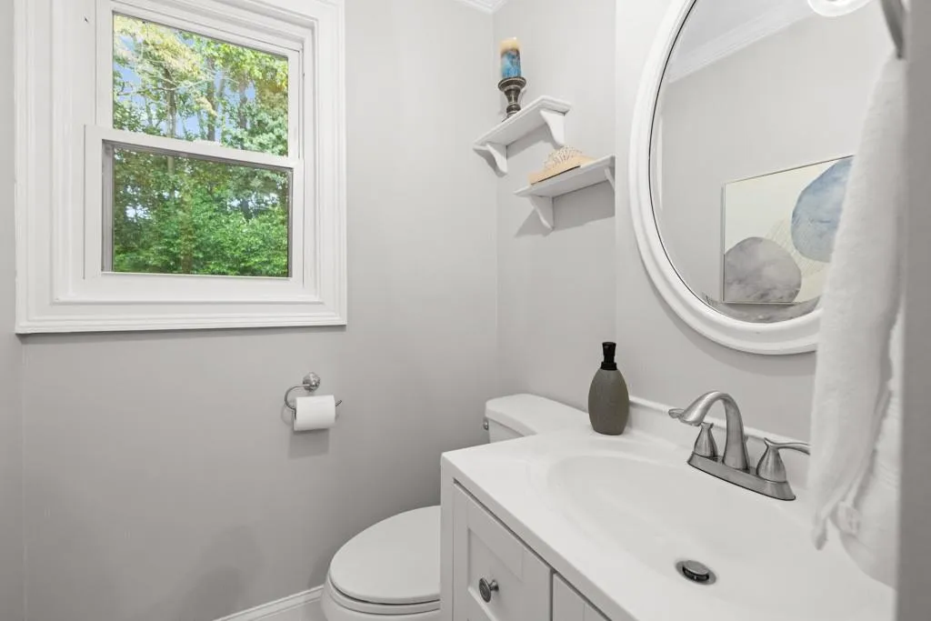 Bathroom with toilet, ornamental molding, and vanity