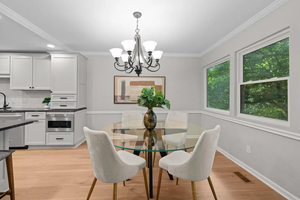 Dining space featuring ornamental molding, light hardwood / wood-style flooring, and a notable chandelier