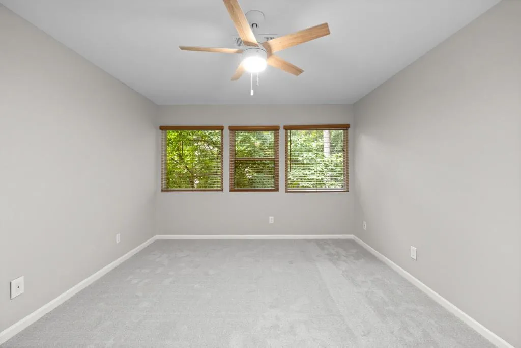Unfurnished room featuring light colored carpet and ceiling fan