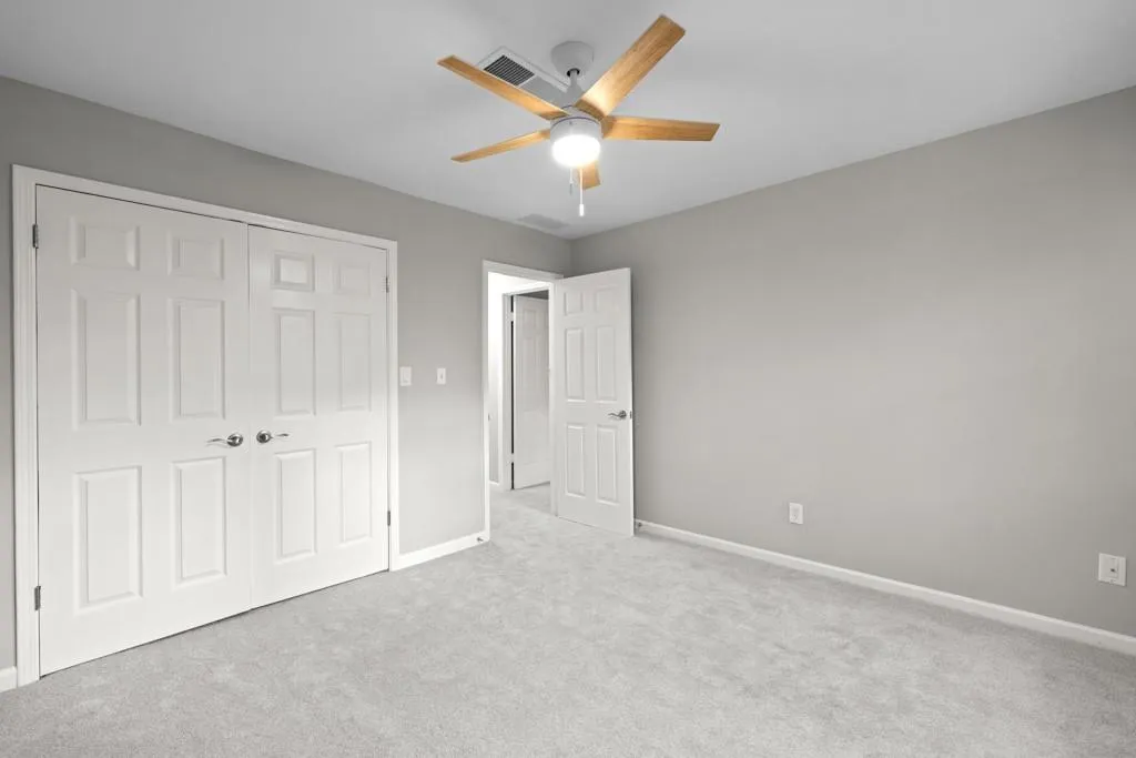 Unfurnished bedroom featuring a closet, ceiling fan, and carpet