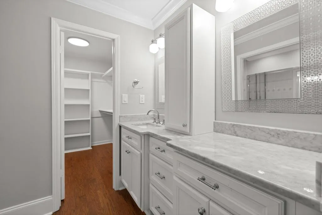 Bathroom with hardwood / wood-style floors, ornamental molding, and vanity