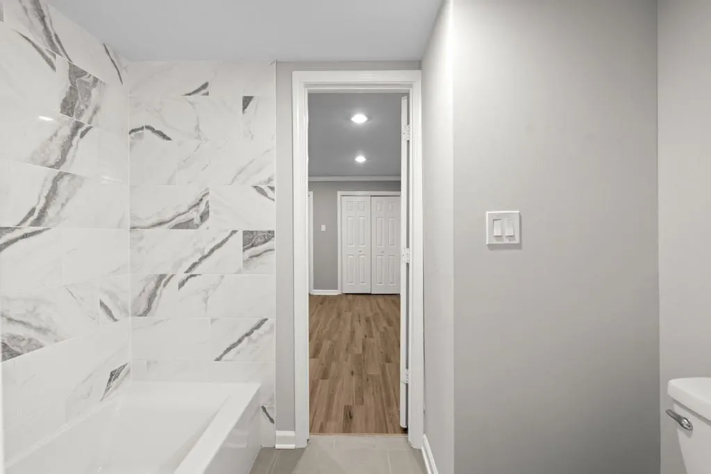 Bathroom featuring toilet, hardwood / wood-style flooring, and a bathing tub