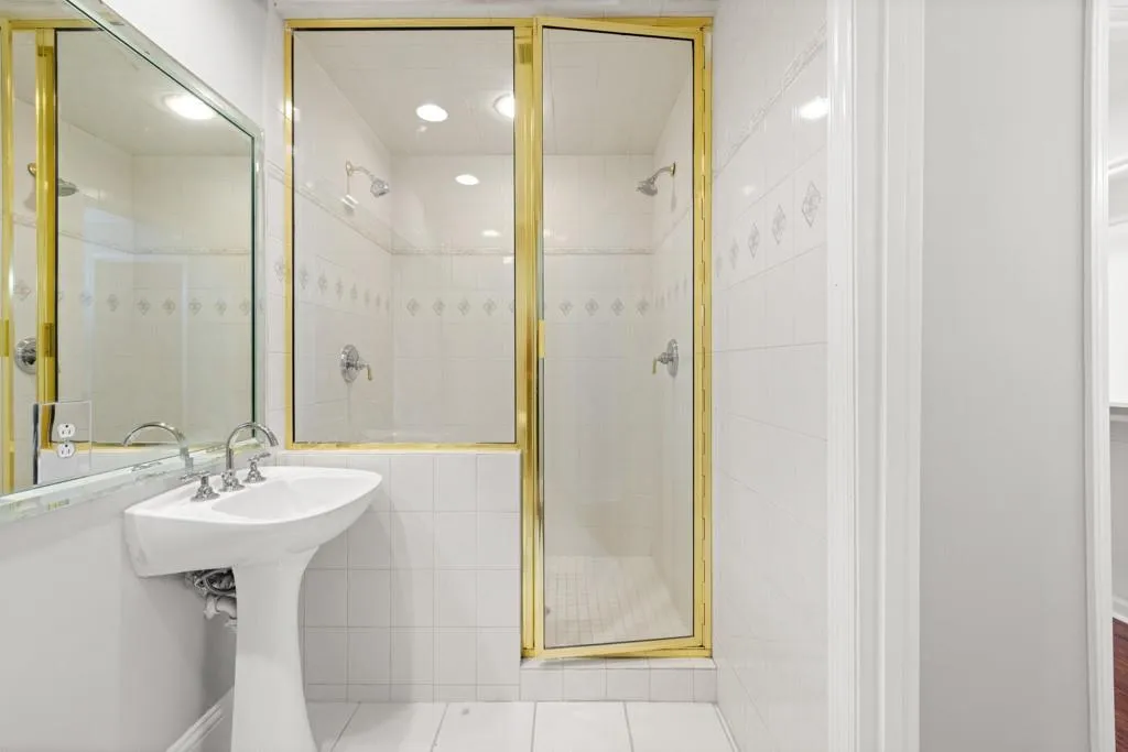 Bathroom with tile patterned flooring, a shower with shower door, and tile walls