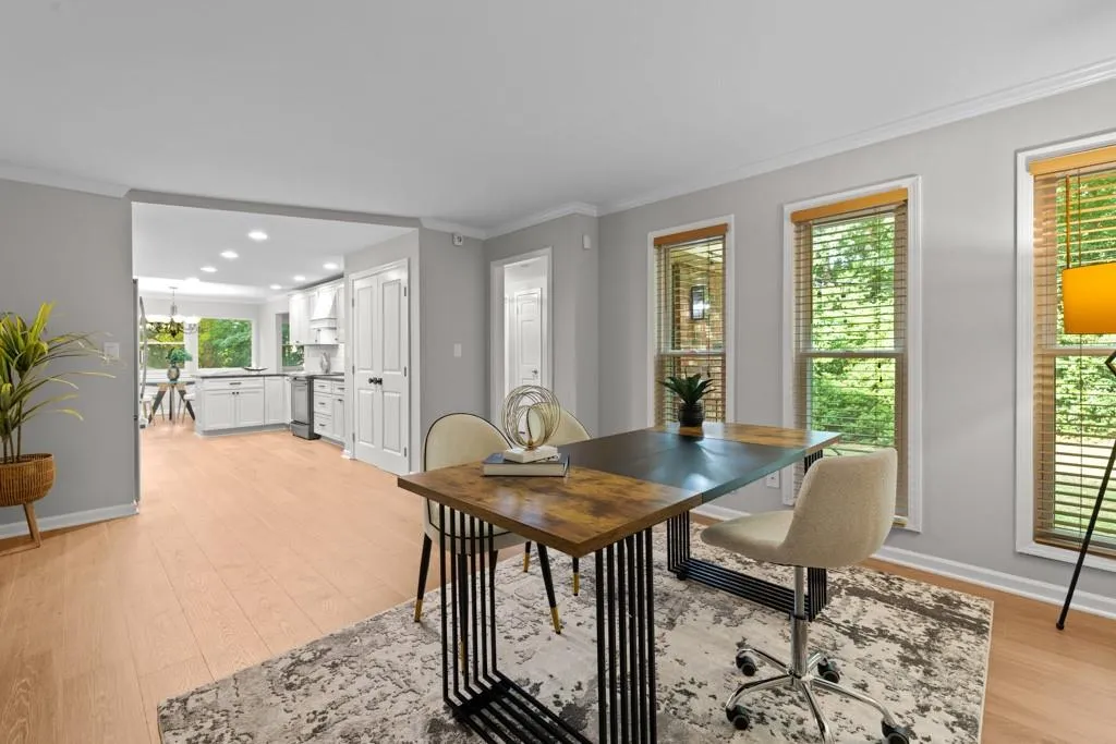 Dining room with ornamental molding and light hardwood / wood-style flooring
