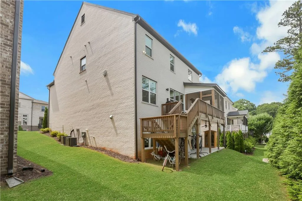 Expansive rear exterior featuring a multi-level wood deck, a screened porch, and a lower-level patio
