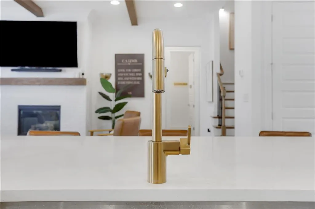 Kitchen island featuring a gold-toned faucet with a white countertop