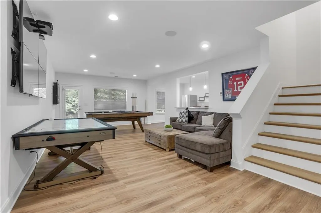 Spacious recreation room featuring wood-finish flooring, recessed lighting, and a walk-out patio door