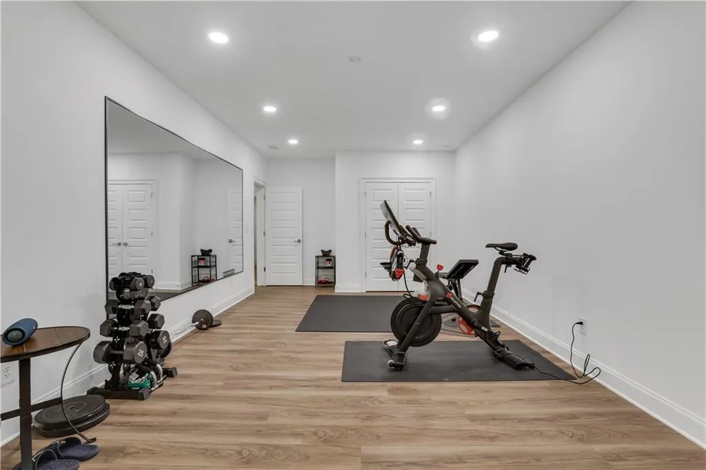 Spacious room featuring wood-finish flooring and recessed lighting