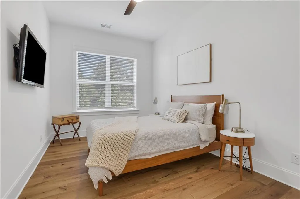 Bright room featuring wood-finish flooring and a ceiling fan