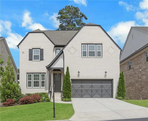 Two-story brick exterior with dark trim accents, a gabled roofline, and a concrete driveway