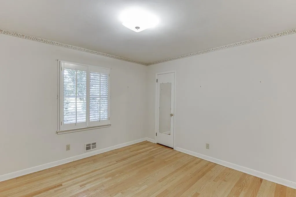 Spare room with visible vents, baseboards, and wood finished floors