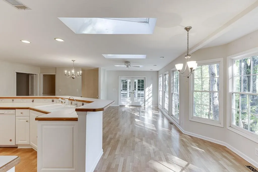 Kitchen featuring a notable chandelier, visible vents, white dishwasher, and a sink
