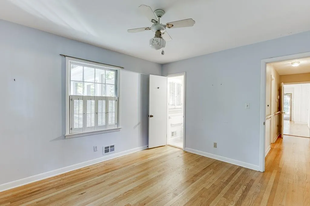 Spare room featuring visible vents, ceiling fan, light wood-type flooring, and baseboards
