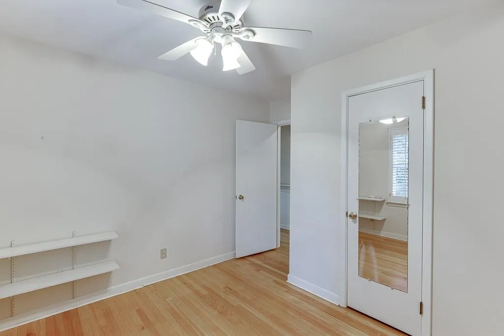 Unfurnished bedroom with baseboards, light wood-style floors, and a ceiling fan
