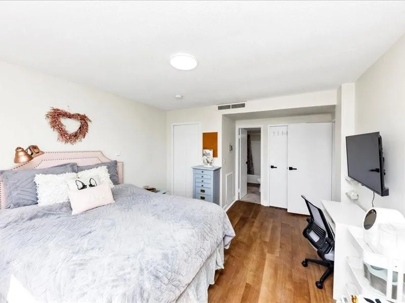 Bedroom with dark wood-style floors and a closet