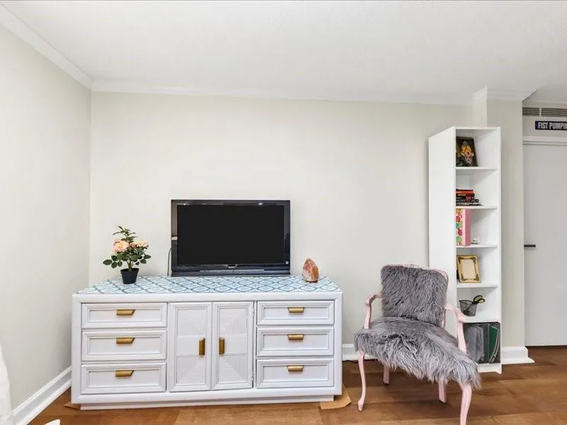 Living area with crown molding and light wood-style flooring