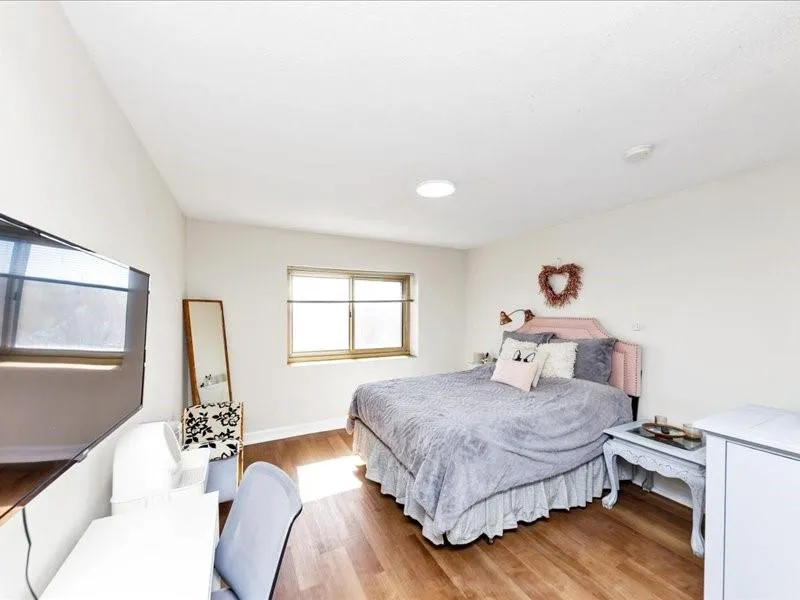 Bedroom with light wood-style floors and a desk