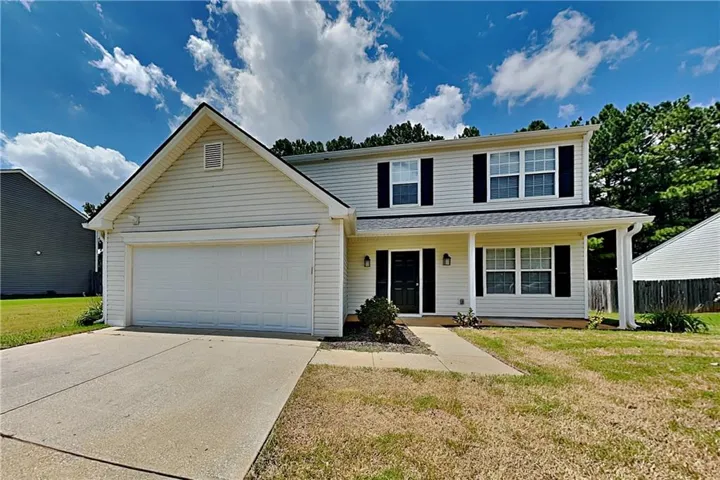 Two-story siding exterior with a covered porch, attached two-car garage, and concrete driveway