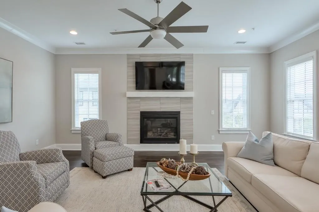 Main Level Living room featuring a fireplace, hardwood flooring, natural light and a ceiling fan