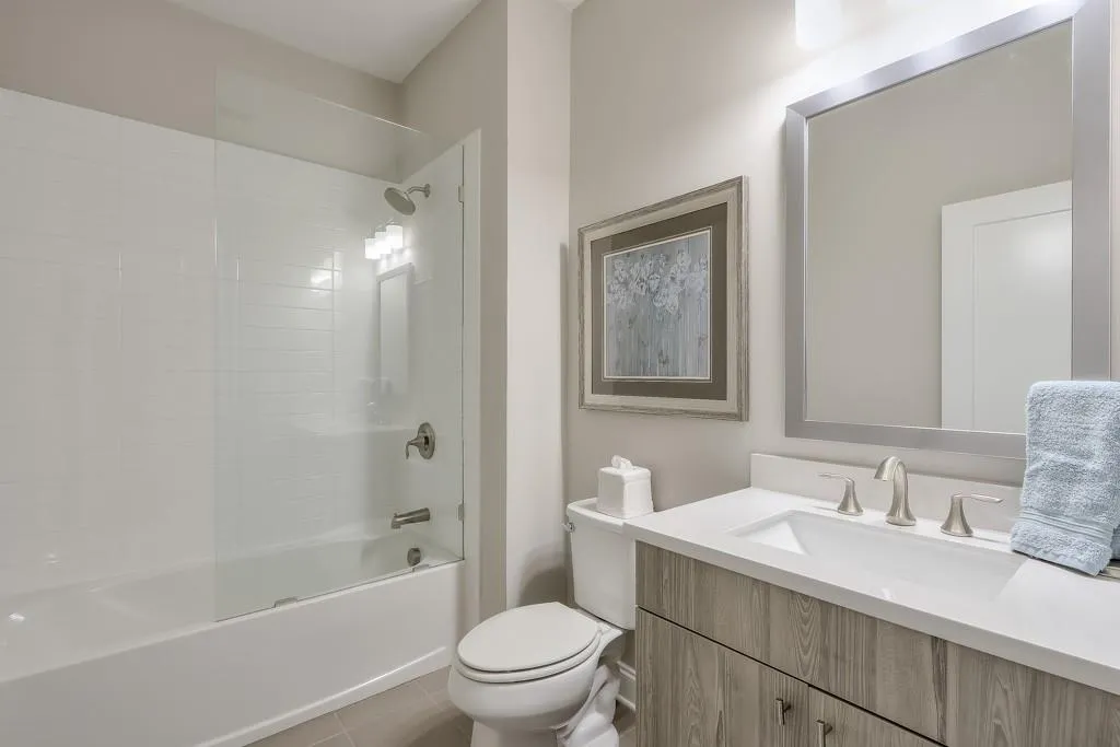Full ensuite featuring tile floors, shower / bath combination, and vanity