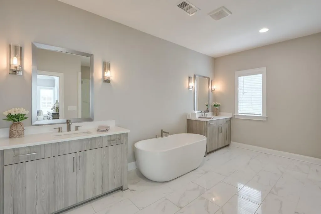 Primary bathroom with two vanities, marble flooring and soaking tub