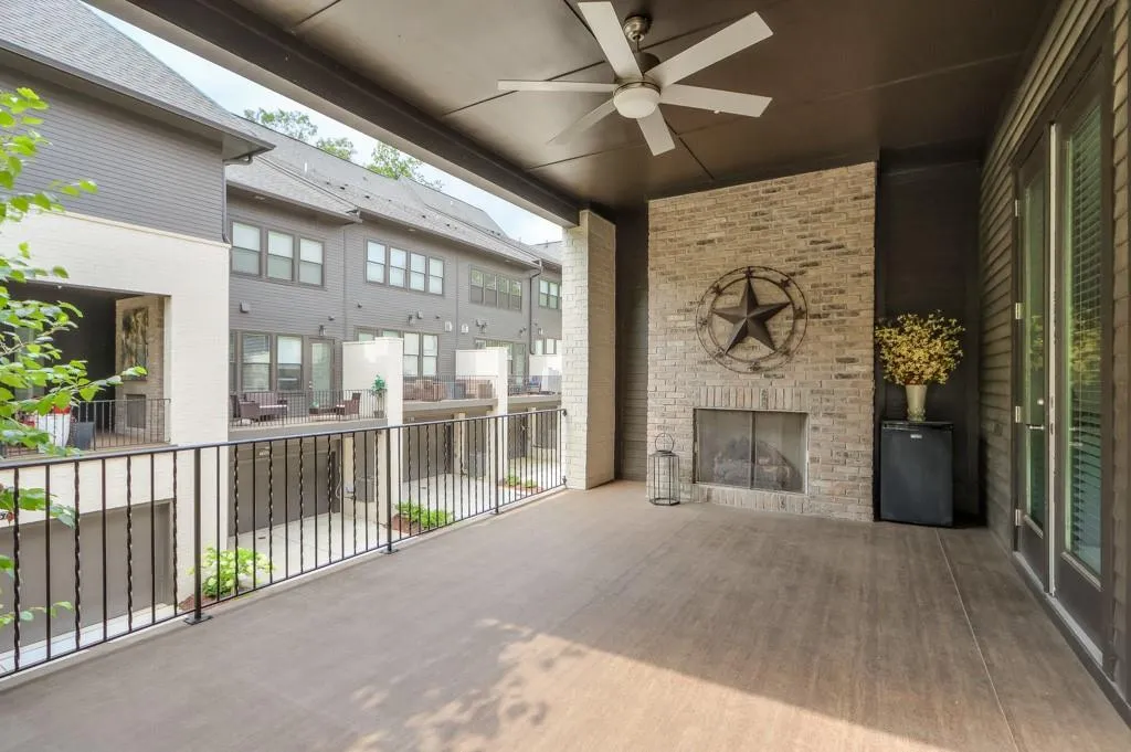 Main level patio featuring a balcony, fireplace, ceiling fan, a grill and French Doors from the kitchen