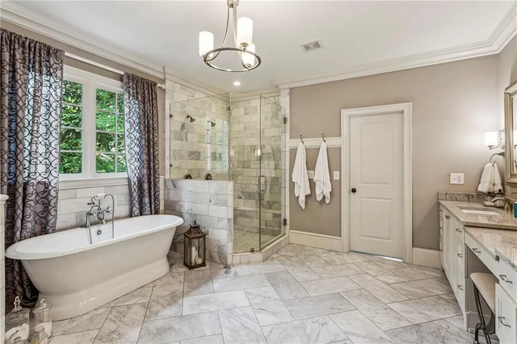 Bathroom featuring a marble shower with dual shower heads, soaking tub