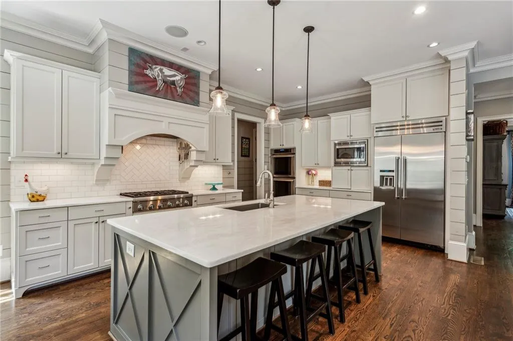 Kitchen featuring all Thermador appliances, tile backsplash, and a large prep island