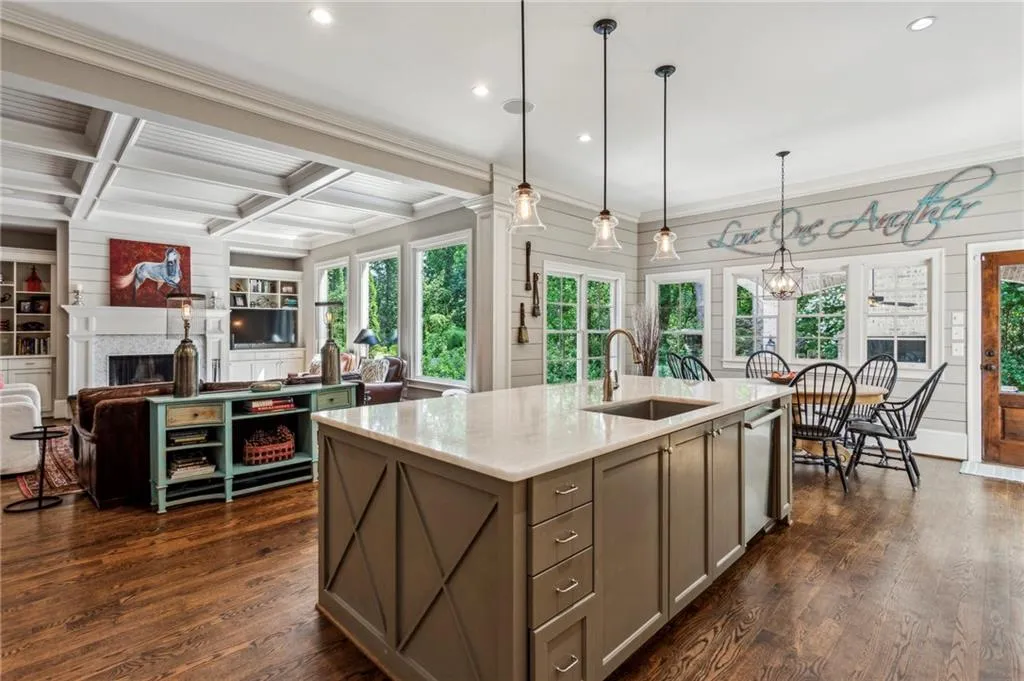 Kitchen with a sink, a fireplace, recessed lighting, beam ceiling, and stainless steel dishwasher