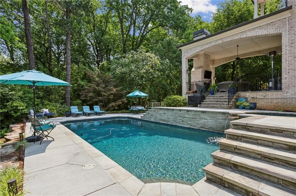 Outdoor saltwater pool featuring a patio, spa with water feature and mature landscaping
