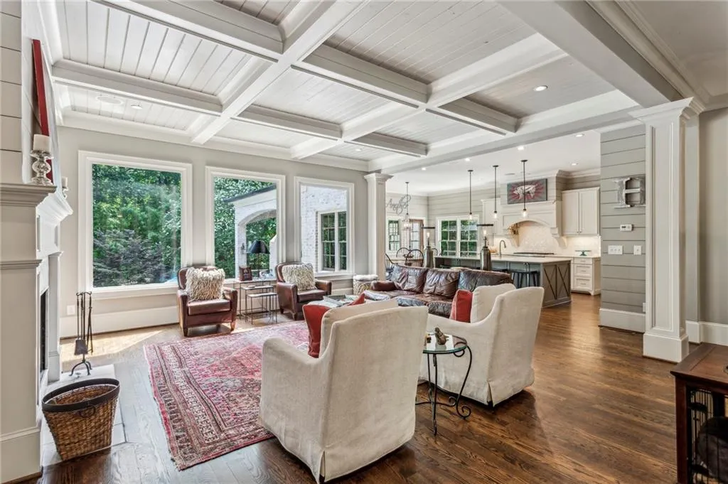 Living area featuring hardwood floors, coffered ceiling, overlooks backyard pool and spa