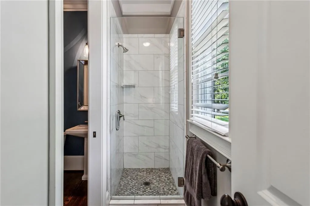 Bathroom featuring a shower stall and wood finished floors