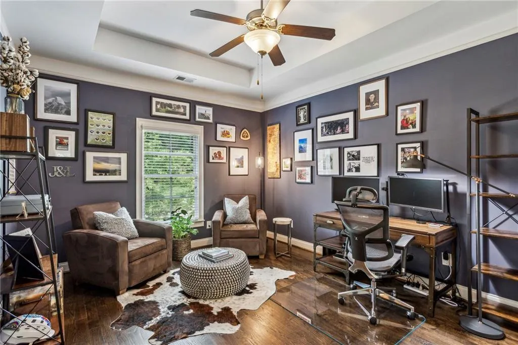 Bedroom #5 serves as an office space featuring a ceiling fan, hardwood / wood-style flooring, a tray ceiling, and baseboards