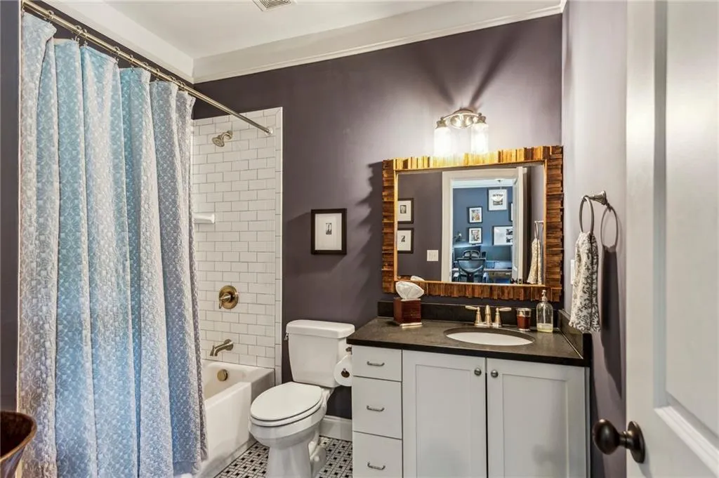 Private bathroom for bedroom #5 with vanity, shower / bathtub combination with curtain, toilet, and tile patterned floors