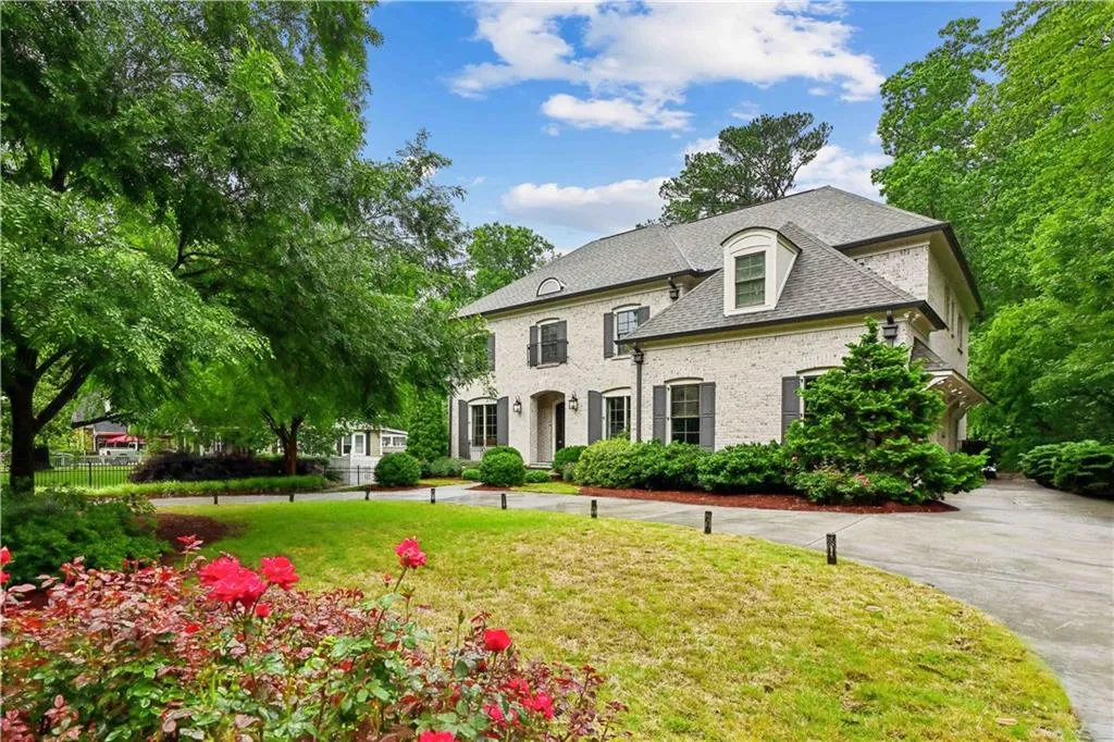 French provincial home with brick siding and side entry 3-car garage