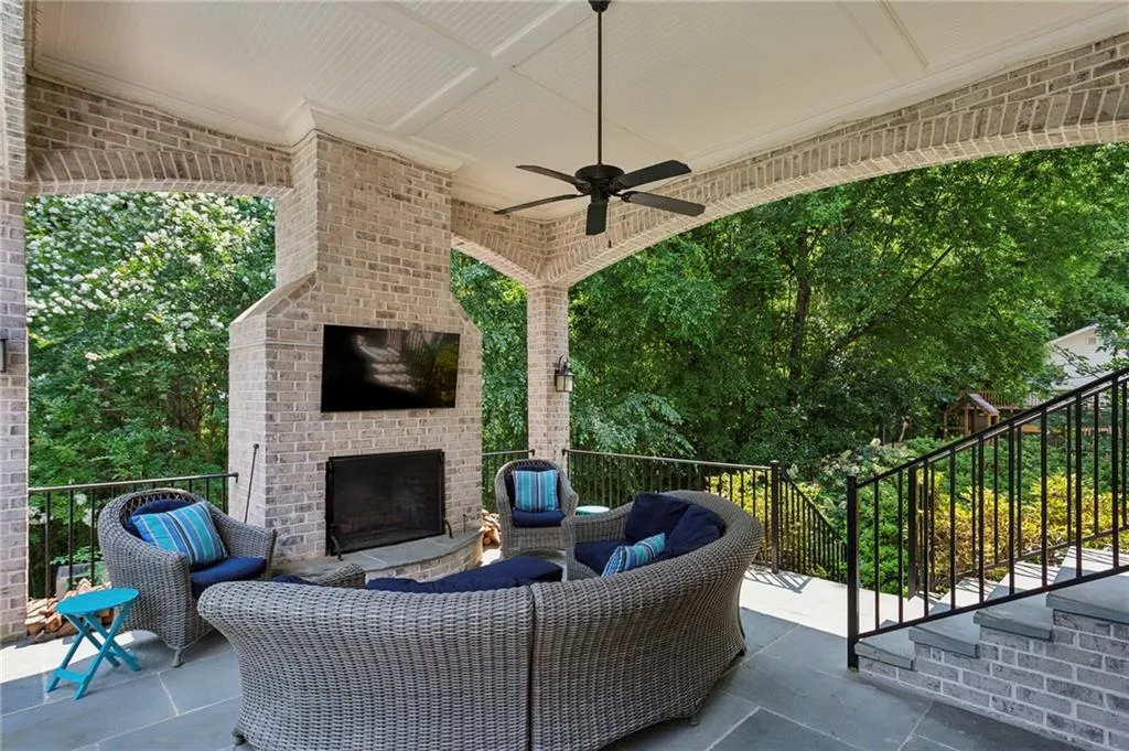 View of patio / terrace with an outdoor living space with a fireplace and ceiling fan