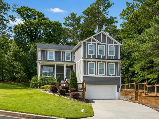 Multi-level siding exterior with a two-car garage and a concrete driveway