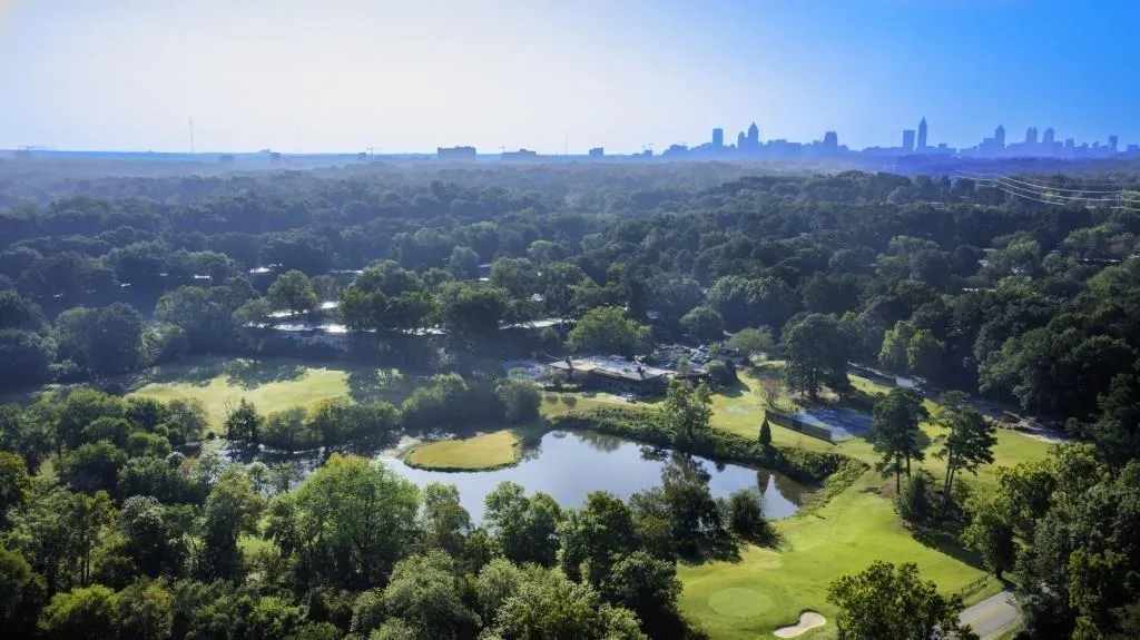 Bird's eye view of a nearby body of water and a heavily wooded area
