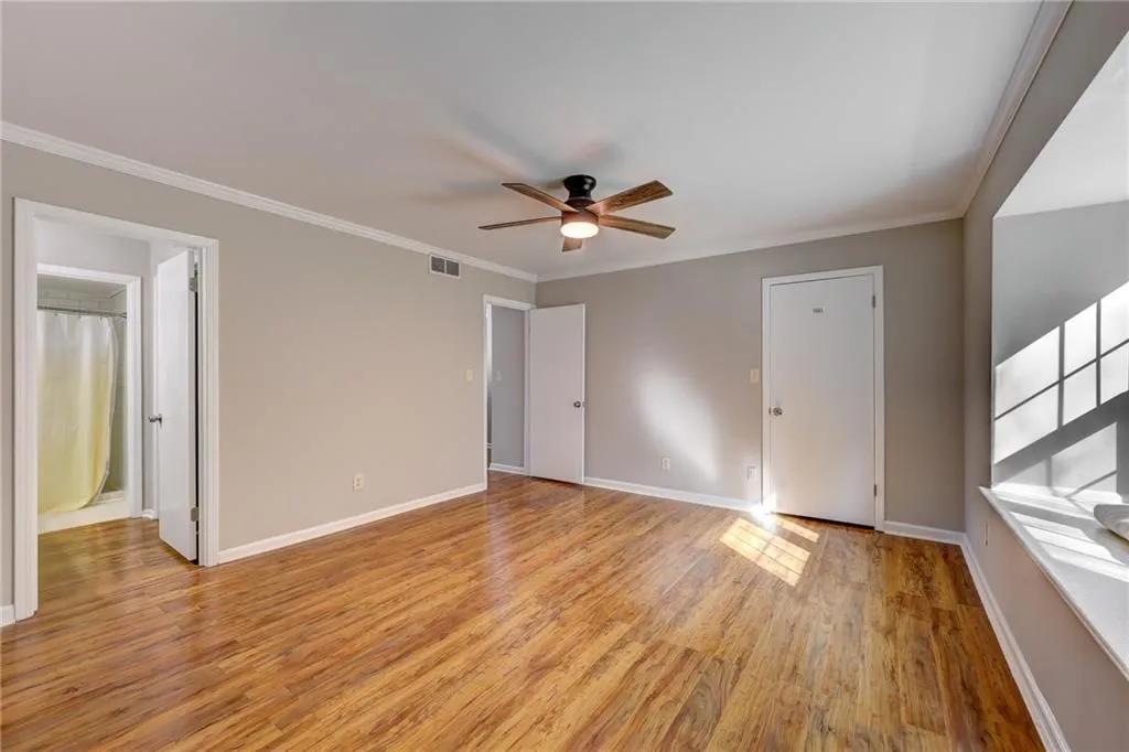 Unfurnished bedroom with ornamental molding, light wood-style flooring, and ceiling fan