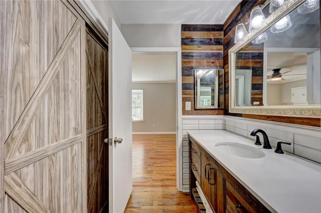 Bathroom with vanity, light wood-style flooring, and backsplash