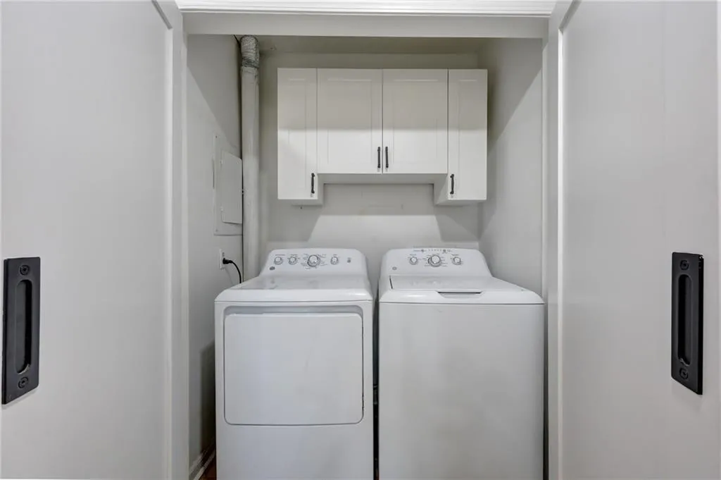 Laundry area featuring cabinet space, separate washer and dryer, and electric panel