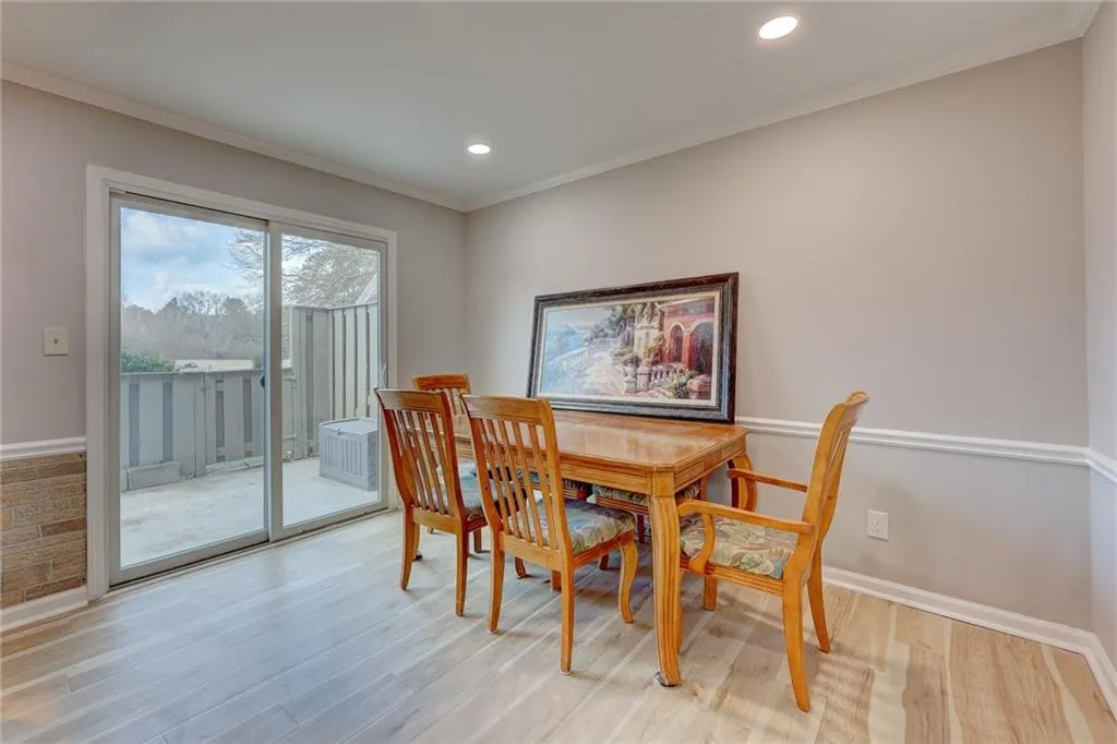 Dining area with crown molding, light wood-type flooring, and recessed lighting