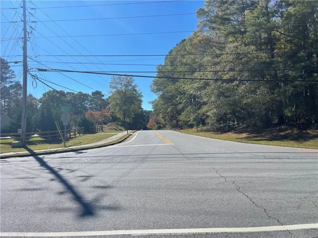View of asphalt street featuring sidewalks and traffic signs