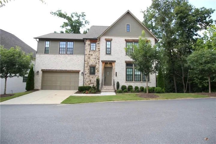 Elegant two-story residence featuring a mixed-material exterior of brick and stone accents, complemented by board-and-batten siding