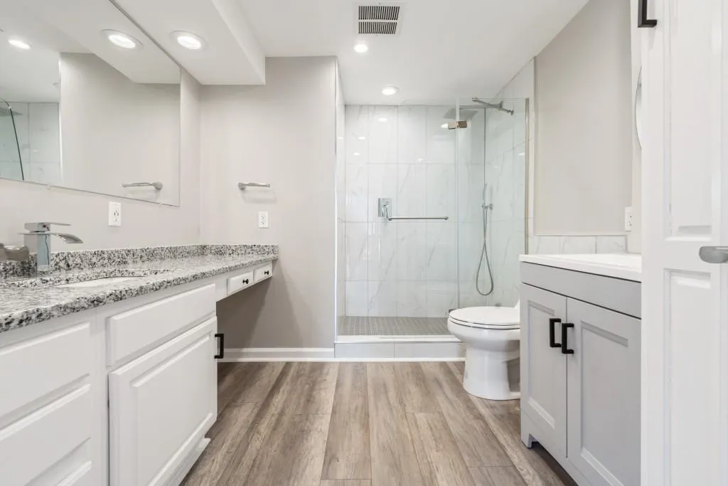 Primary bath renovated with tiled shower, two vanities, & lots of cabinet space for storage