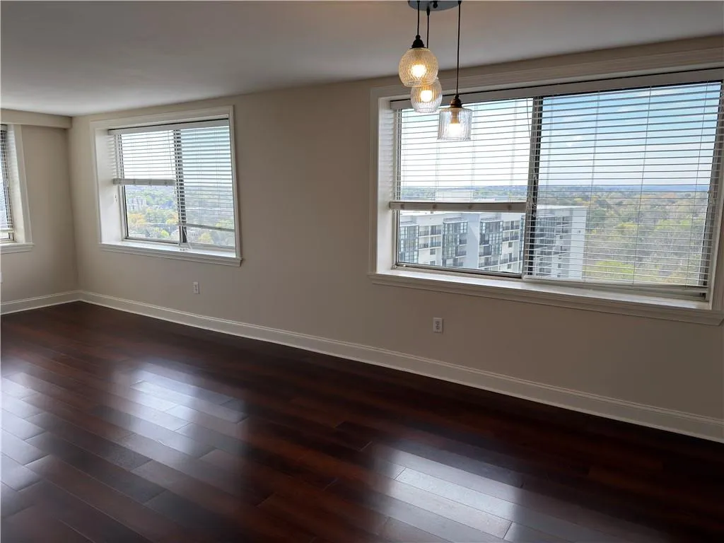 Spare room featuring dark wood finished floors and baseboards