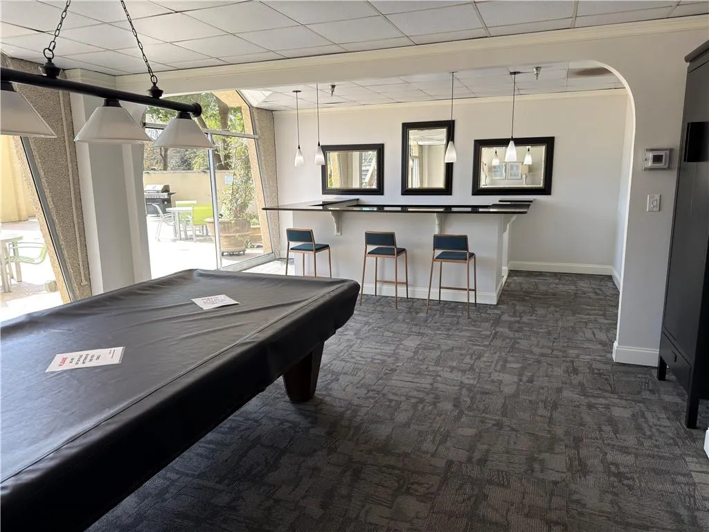 Playroom with pool table, a drop ceiling, and arched walkways